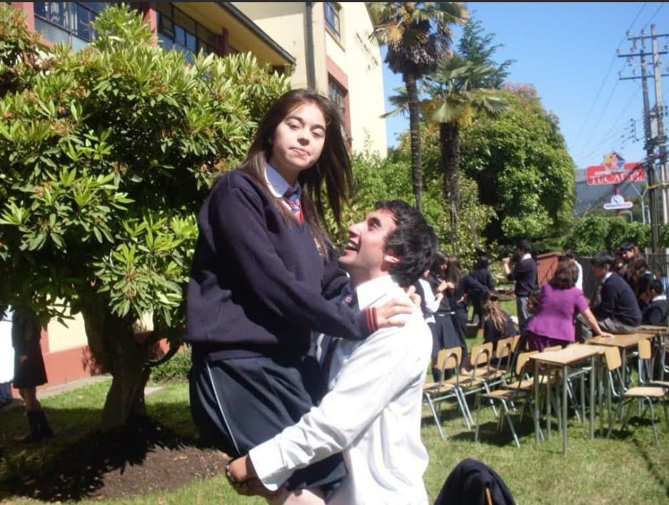 Diego levanta a Fernanda en el patio del liceo, ambos con uniforme escolar